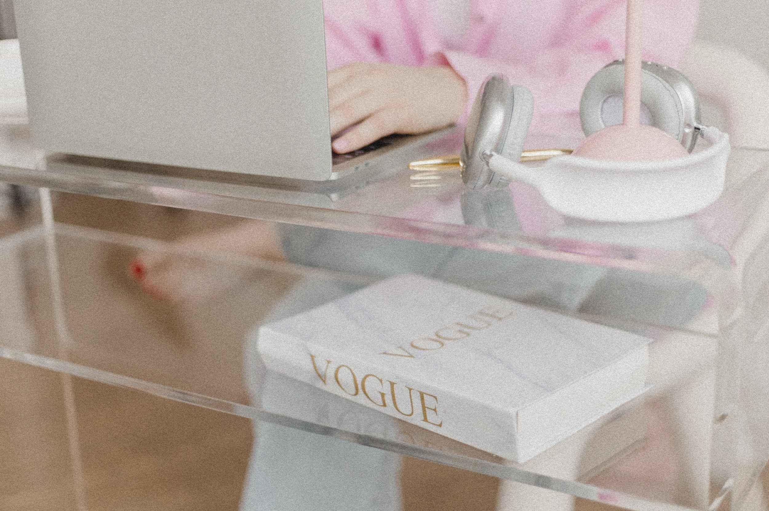 Wie ich mein Business durch organische Suchmaschinenoptimierung explodieren ließ Ästhetischer Arbeitsplatz mit Vogue-Buch, Laptop und Headset – moderne Suchmaschinenoptimierung trifft auf Design und Klarheit.