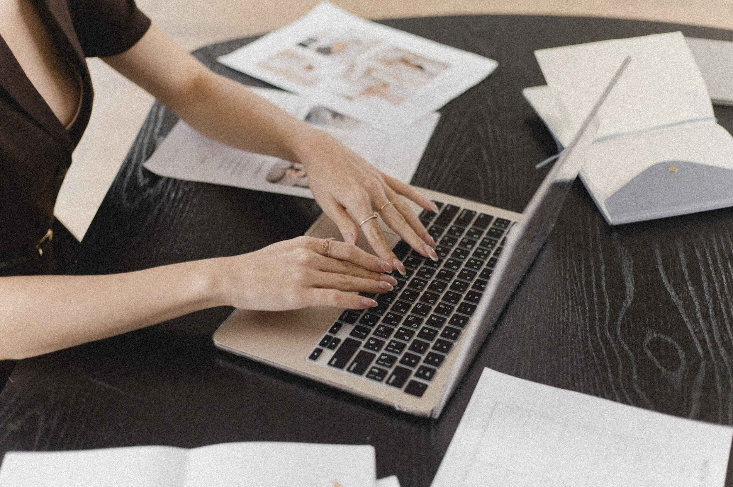 Generative Engine Optimization Content-Erstellung am Laptop mit Printmaterialien – strategisches Schreiben für Generative Engine Optimization.