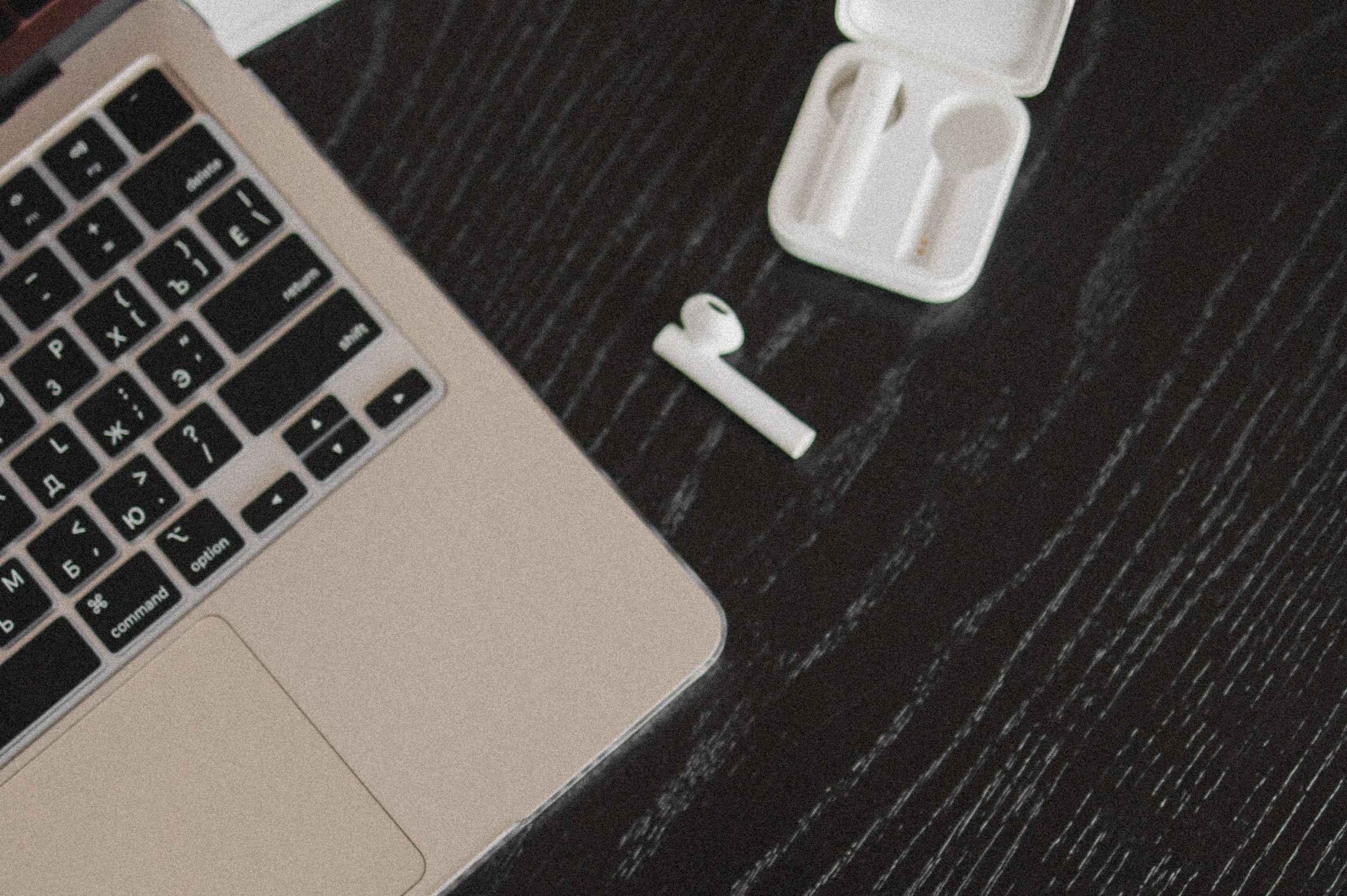 Unterschied GEO und SEO1 Laptop mit Notizbuch und Earbuds – Symbolbild für strategische Arbeit am Unterschied zwischen GEO und SEO.