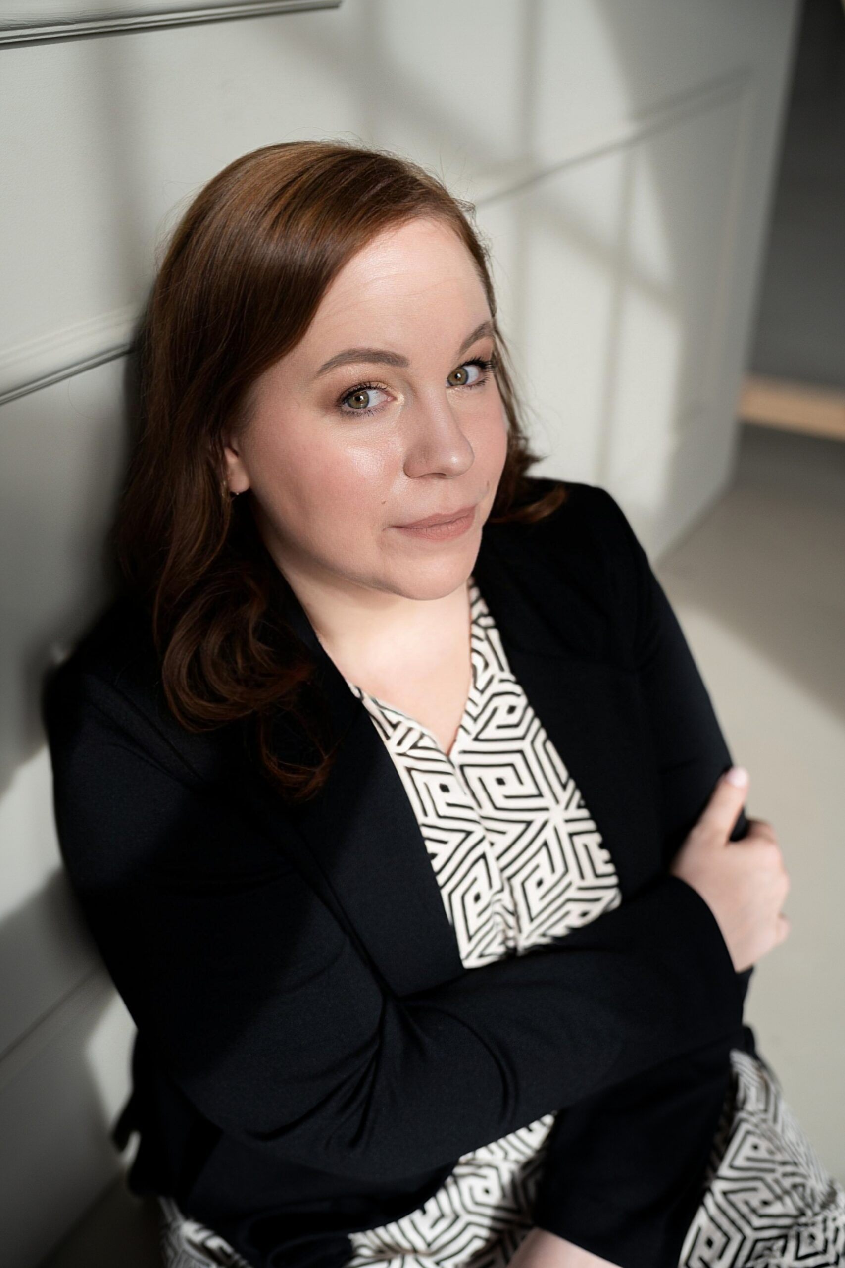 DSC09160 Portrait von Sabine Mastrolorito in natürlichem Licht: mit schulterlangen braunen Haaren und schwarzem Blazer sitzt an eine helle Wand gelehnt. Sie blickt ruhig und selbstbewusst in die Kamera – professionell, sympathisch und nahbar. Das Bild betont ihre Expertise im Bereich Webdesign für Unternehmerinnen.