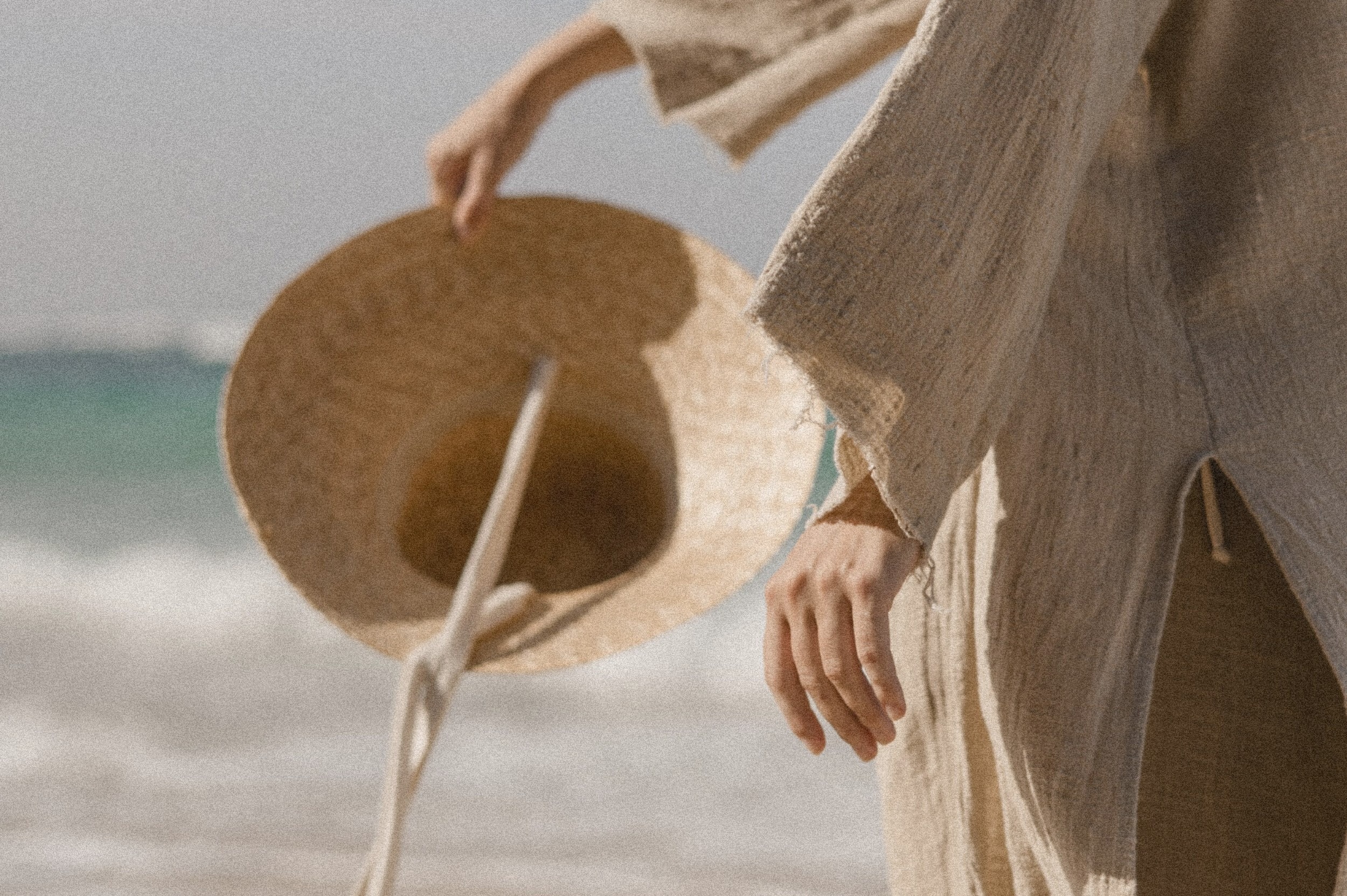 Storytelling Webdesign Detailaufnahme einer Frau mit Strohhut am Meer – ästhetische Bildsprache, die die Kraft von Storytelling im Webdesign visuell unterstreicht.